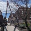 Regal Tree arborist using a bucket truck to assess winter tree damage near commercial buildings in Massachusetts.